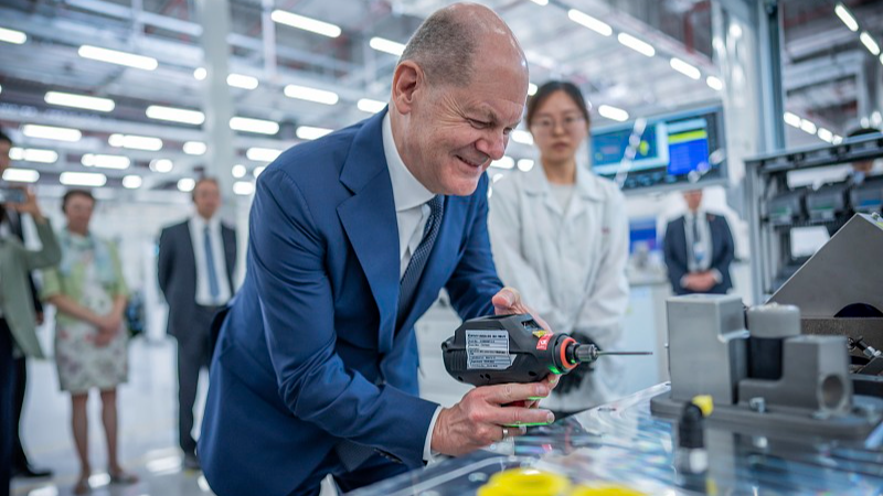 German Chancellor Olaf Scholz visits the Bosch company with its hydrogen drive production facility in Chongqing, southwest China, and tries out a cordless screwdriver in production, April 14, 2024. /CFP