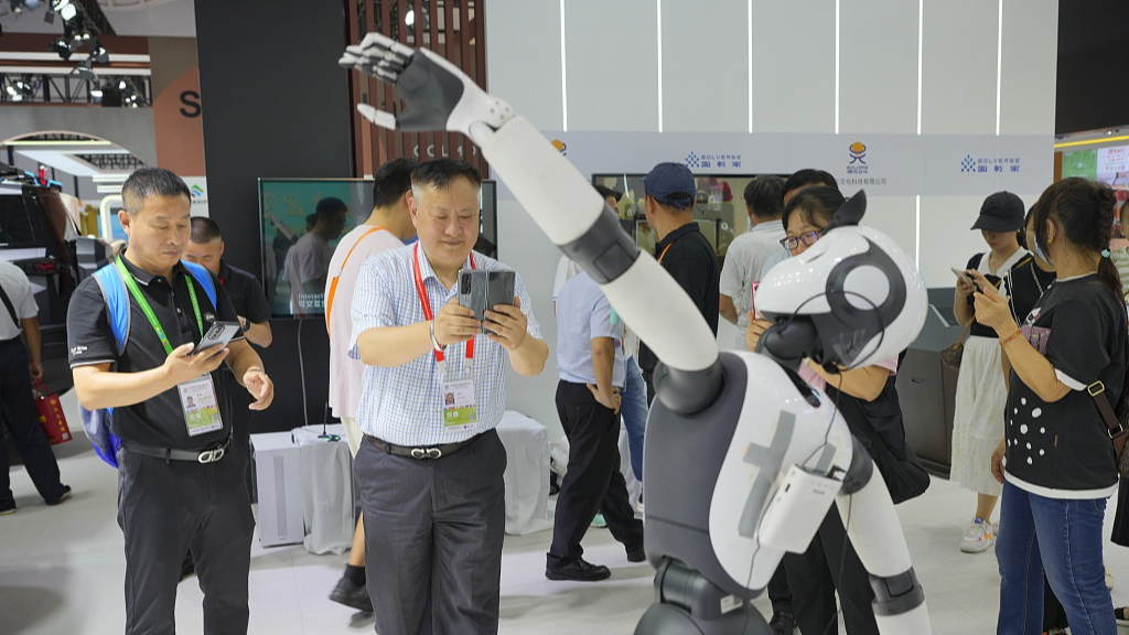 People watch a demonstration of a robot at the 4th China International Consumer Products Expo in Haikou, capital of south China's Hainan Province, April 13, 2024. /CFP