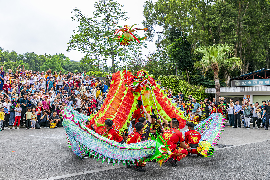 A troupe performs with a dragon dance costume as spectators look on in Nanning, Guangxi, April 12, 2024. /CFP