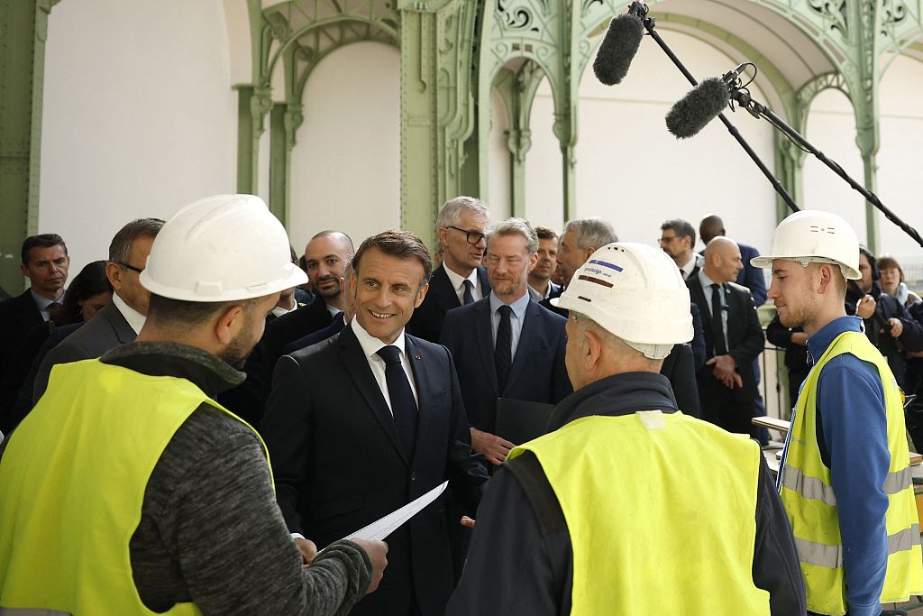 French president Emmanuel Macron (C) listens to workers during a visit at the Grand Palais in Paris, France, April 15, 2024. /CFP