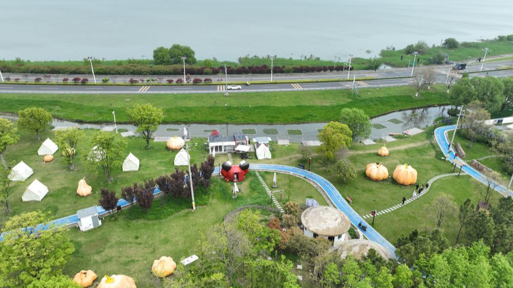 An aerial drone photo taken on April 11, 2024, shows tourists visiting a resort near Taihu Lake in Wuxing District of Huzhou City, east China's Zhejiang Province. /Xinhua