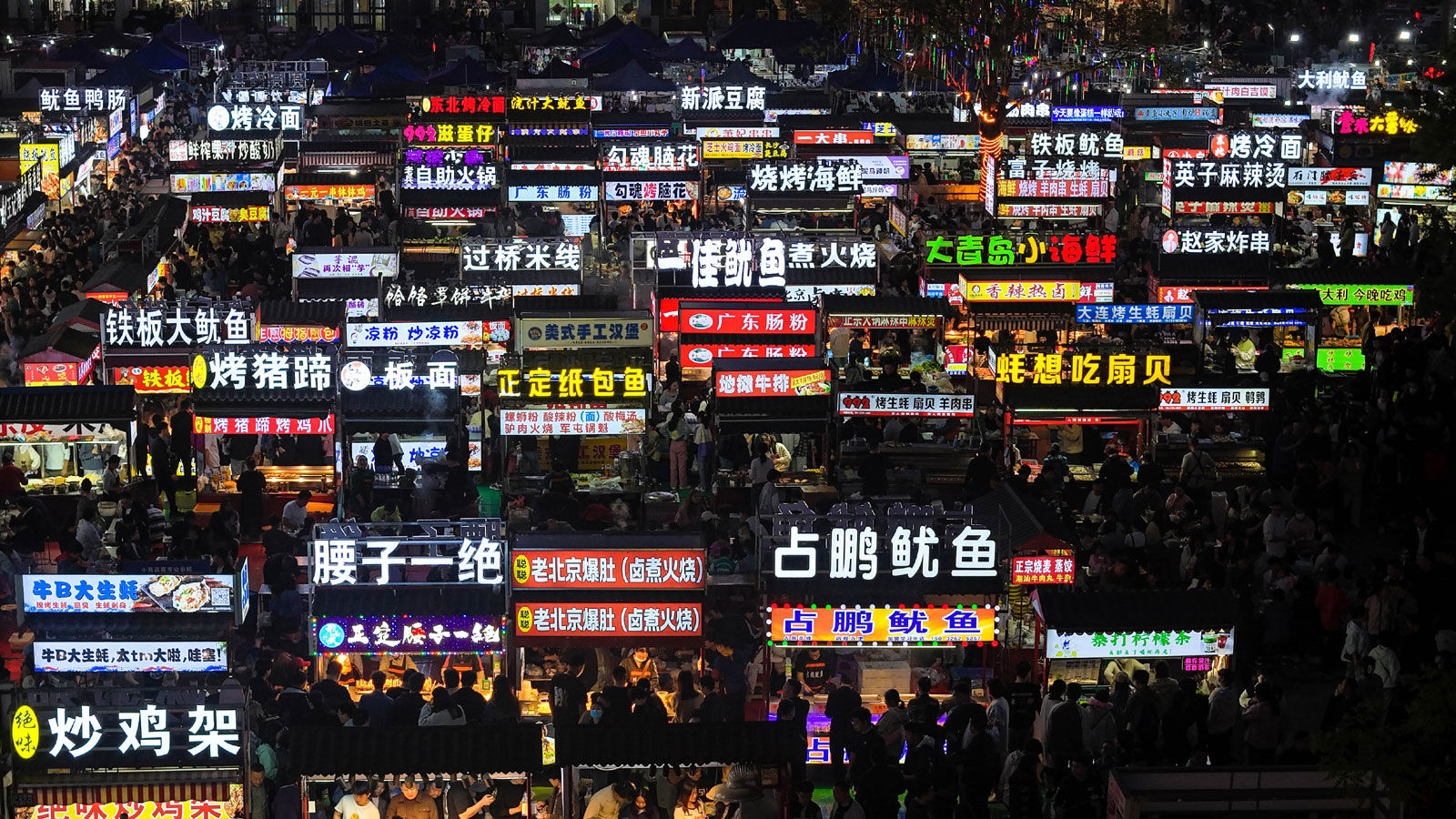 Signboards of food stalls shine under the night sky at the night market at the Zhengding International Small Commodities Market in Hebei Province on April 14, 2024. /IC