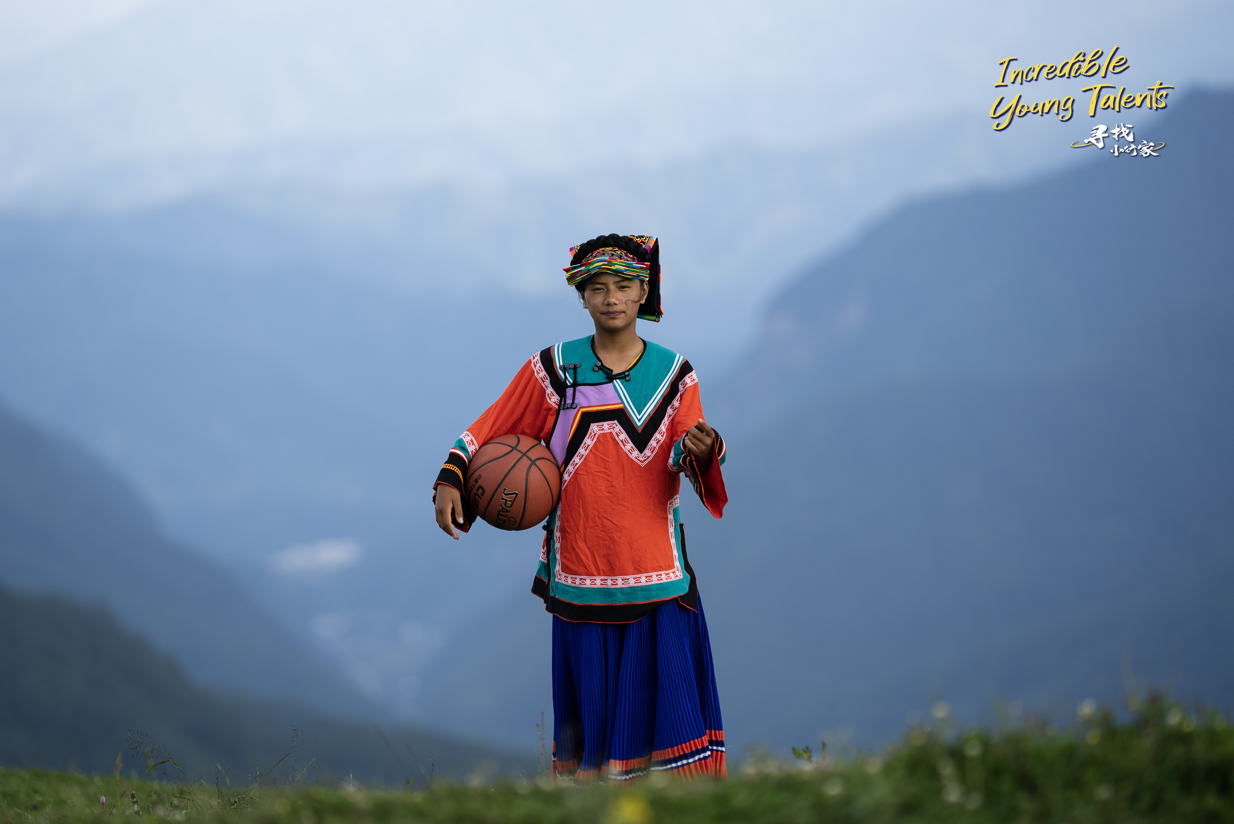 An undated photo shows 13-year-old girl Aguolieha wearing Yi ethnic clothing with a basketball under her arm in the mountainous Liangshan Yi Autonomous Prefecture in southwest China's Sichuan Province. /CGTN