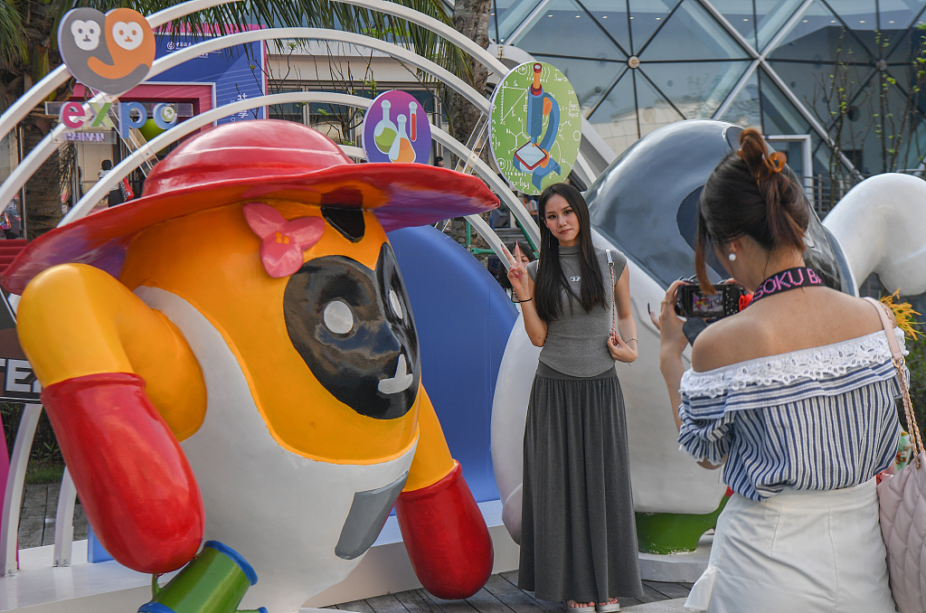 A visitor takes photos with the Expo's mascot at the fourth China International Consumer Goods Expo in Haikou, south China's Hainan Province, April 13, 2024. /CFP
