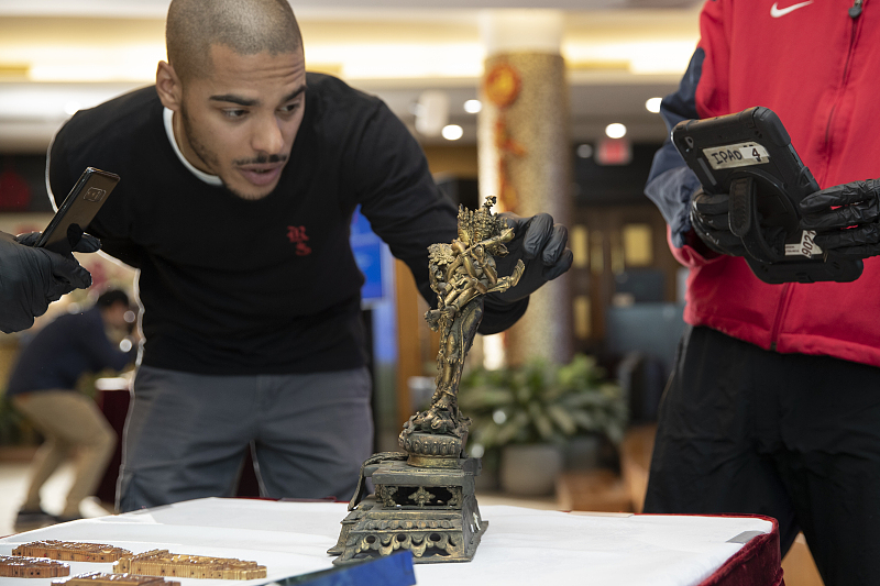 Staff members check the condition of returned Chinese cultural objects at a handover ceremony at the Chinese Consulate General in New York, the United States, on April 17, 2024. /CFP