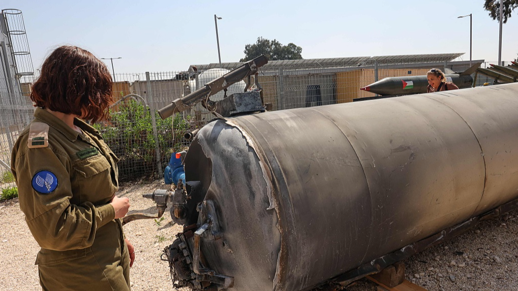 A member of the Israeli military stands next to an Iranian ballistic missile, which fell in Israel on the weekend, at the Julis military base near the southern Israeli city of Kiryat Malachi, April 16, 2024. /CFP