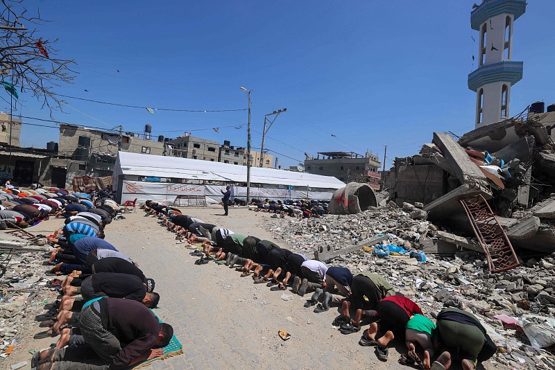 Palestinians perform Friday noon prayer next to the ruins of Al-Farouq Mosque, destroyed during Israeli bombardment in Rafah in the southern Gaza Strip, April 19, 2024. /CFP