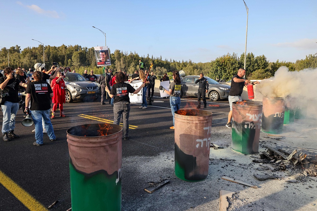 Relatives and supporters of Israeli hostages held in Gaza since the October 7 attacks chant slogans as they block the Ayalon highway between Tel Aviv and Jerusalem near Latrun with burning barrels, during a protest calling for their release, April 19, 2024. /CFP