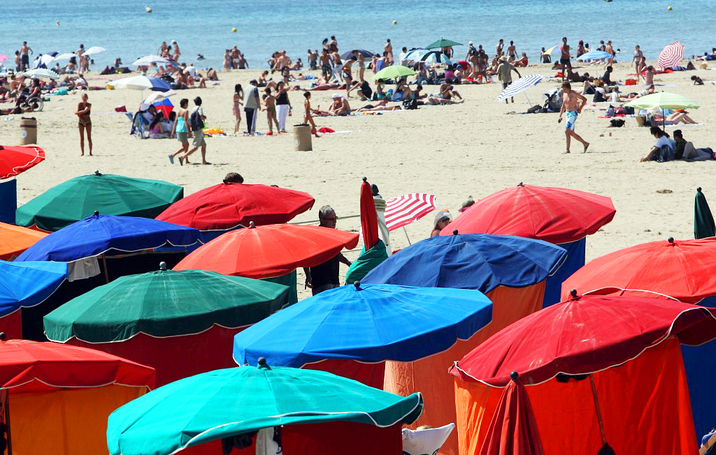 People enjoy the sunshine on the beach of Deauville, France. /CFP