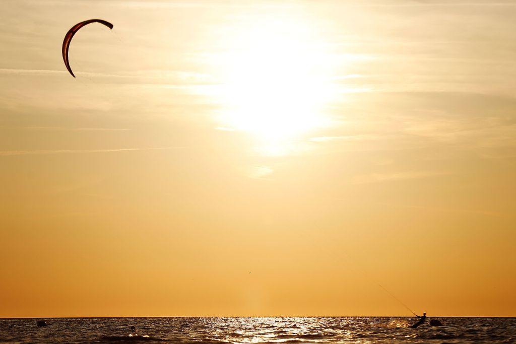 A kite-surfer practices at sunset in Deauville, France. /CFP