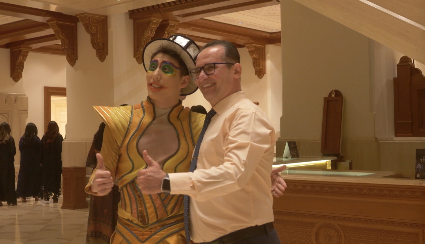 A local audience member takes picture with a member of the Xi'an Acrobatic Troupe at the Royal Opera House in Oman on April 18, 2024. /Photo provided to CGTN