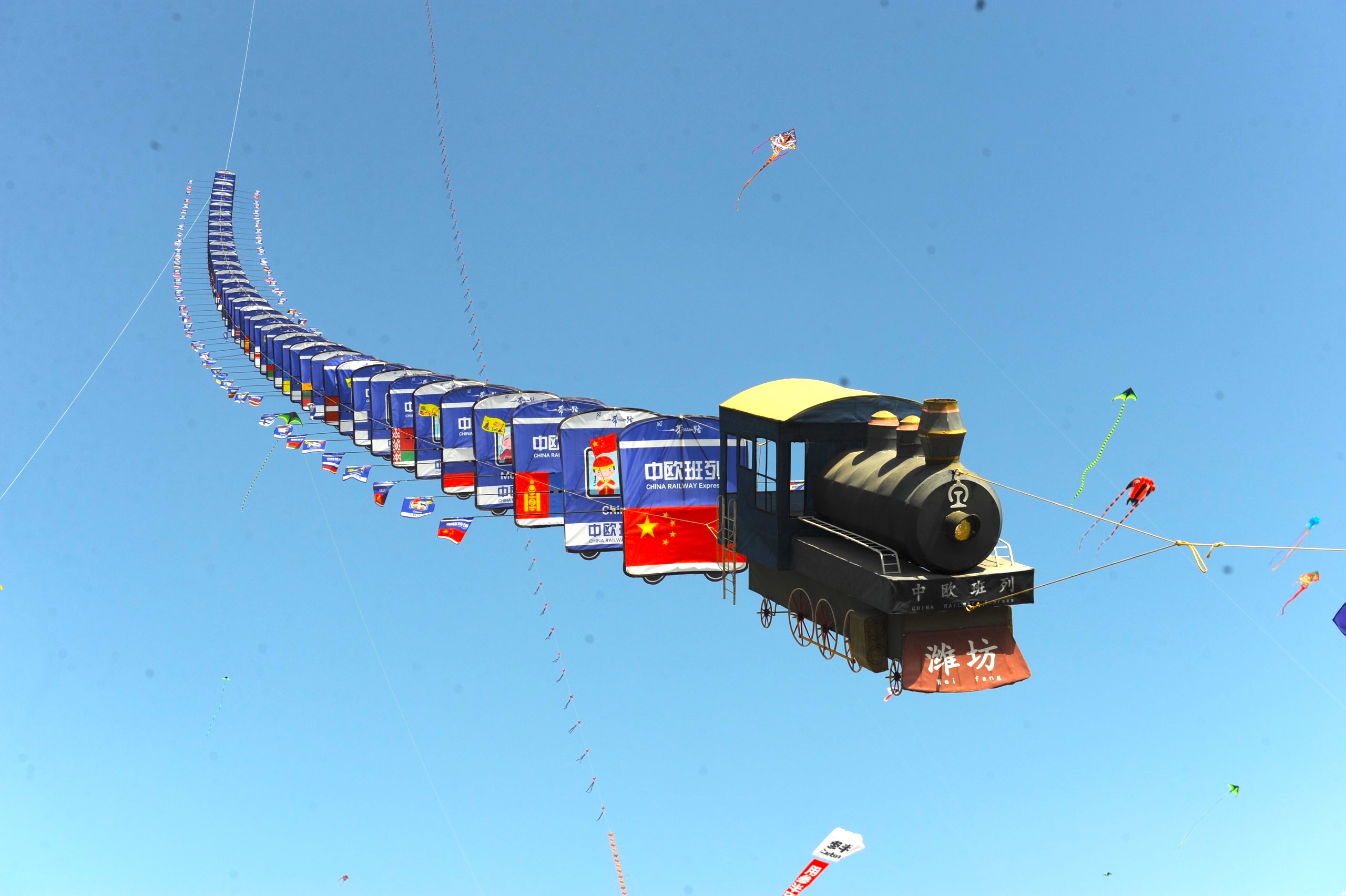 A kite in the shape of the China-Europe freight train flies during the 20th World Kite Championship held in Weifang, east China's Shandong Province on April 20, 2024. /IC