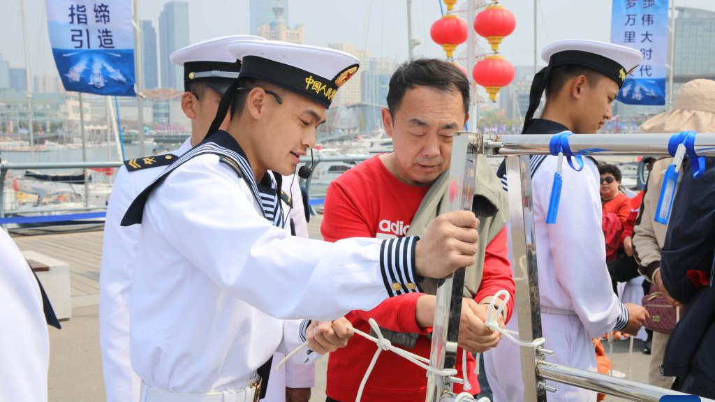 A visitor learns to tie knot at Qingdao International Sailing Center pier in Qingdao, east China's Shandong Province, April 22, 2024. /Xinhua