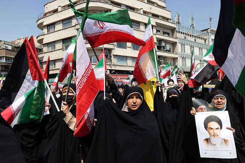 Iranians wave the flags of Palestine and Iran as they gather during an anti-Israel demonstration after noon prayers in Tehran, April 19, 2024. /CFP 