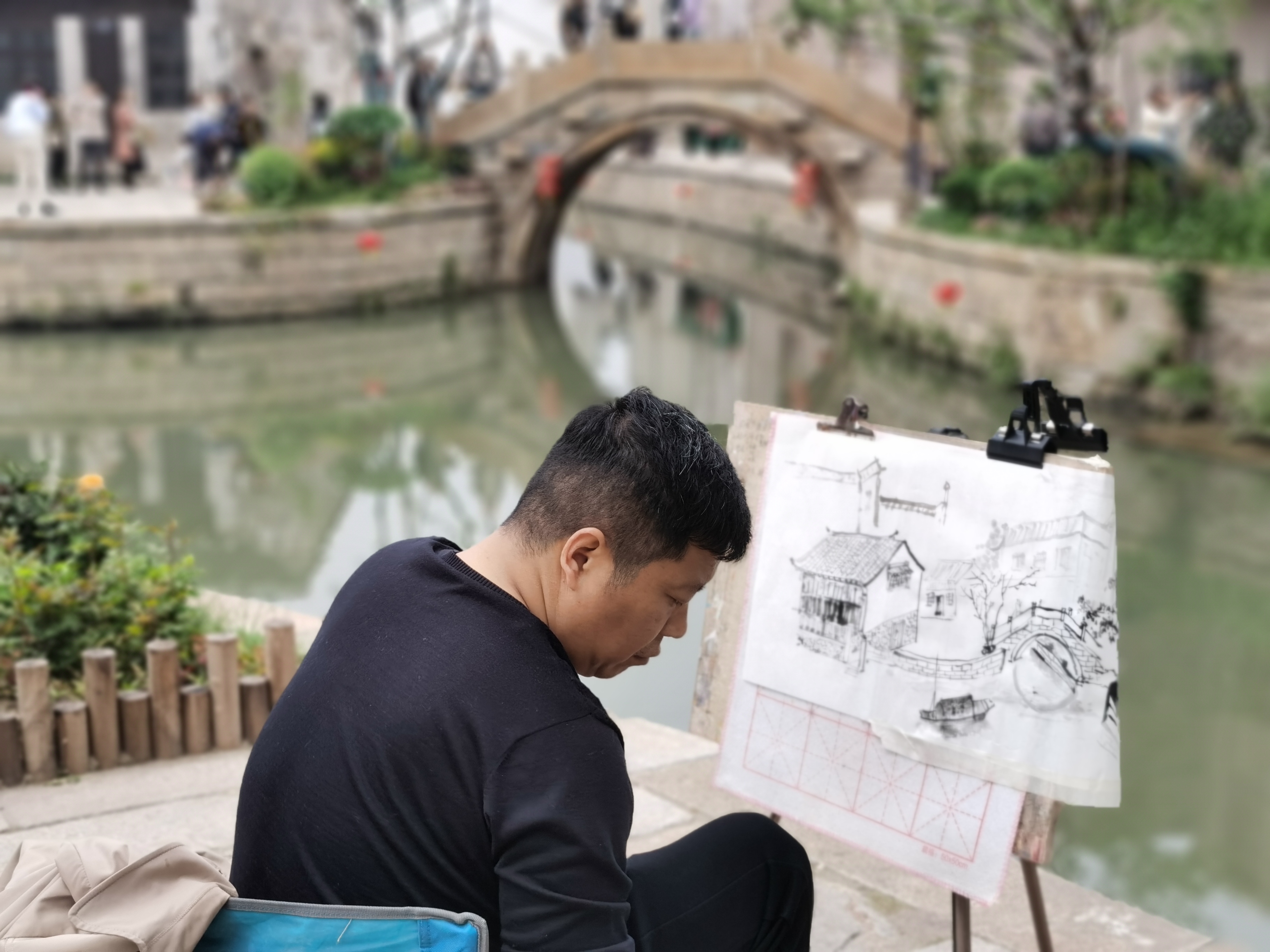A man sketches buildings in Jiaoxi Town, Changzhou City, east China's Jiangsu Province, April 21, 2024. Du Junzhi/CGTN