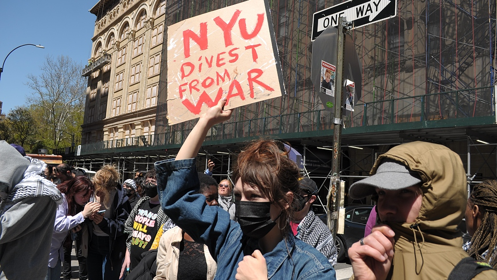 A pro-Palestine protester holds a placard during a demonstration at New York University, April 22, 2024. /CFP