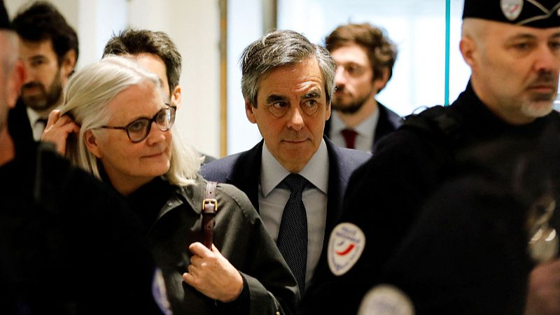Former French Prime Minister Francois Fillon (C) and his wife Penelope Fillon (L) arrive at the Paris courthouse for the requisitions part of their trial accusing them of embezzlement of more than one million euros in the context of an alleged job fraud, March 10, 2020. /CFP