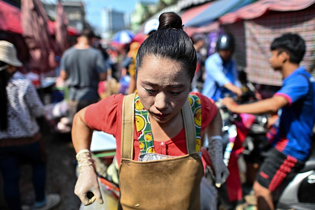 A vendor sweats from the heat as she pulls a cart at Khlong Toei Market, the biggest fresh market in Bangkok, Thailand, April 25, 2024. /CFP