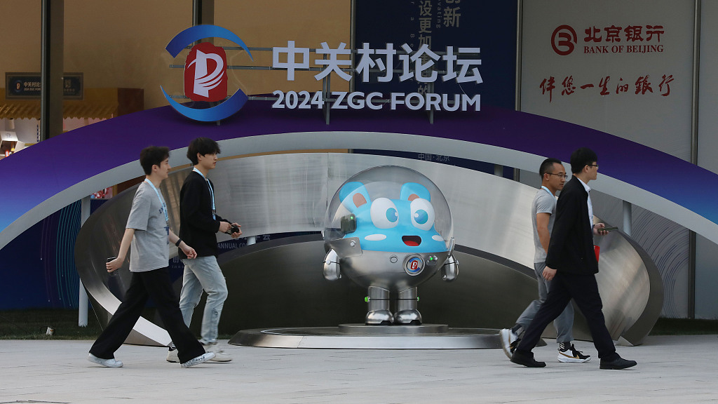 People walk past the mascot of the Zhongguancun Forum at the Zhongguancun International Innovation Center in Beijing, capital of China, April 25, 2024. /CFP