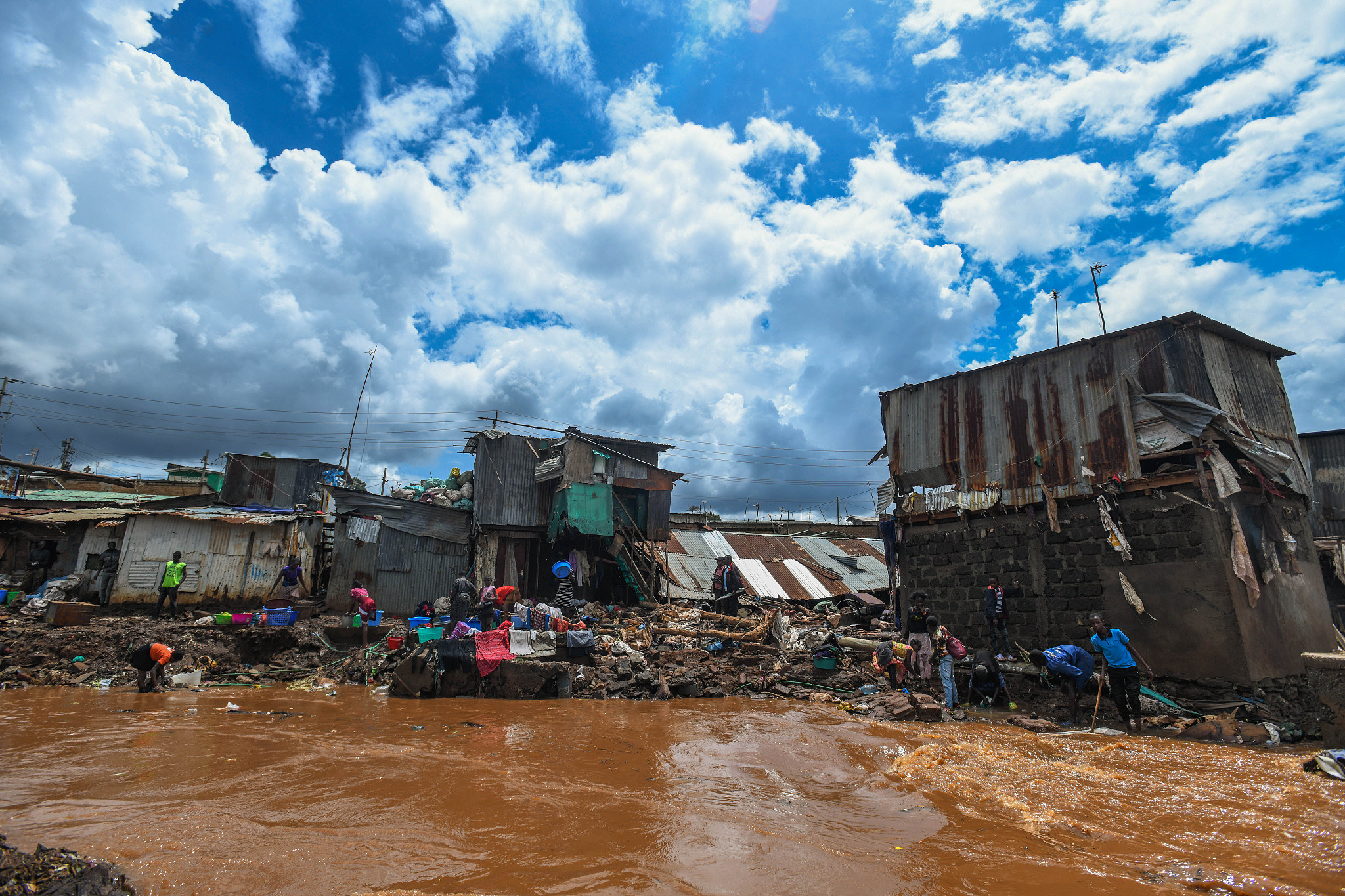 Residents are seen in a flooded street in the Mathare neighborhood after heavy rains as they try to evacuate the area with their important belongings in Nairobi, Kenya, April 25, 2024. /CFP