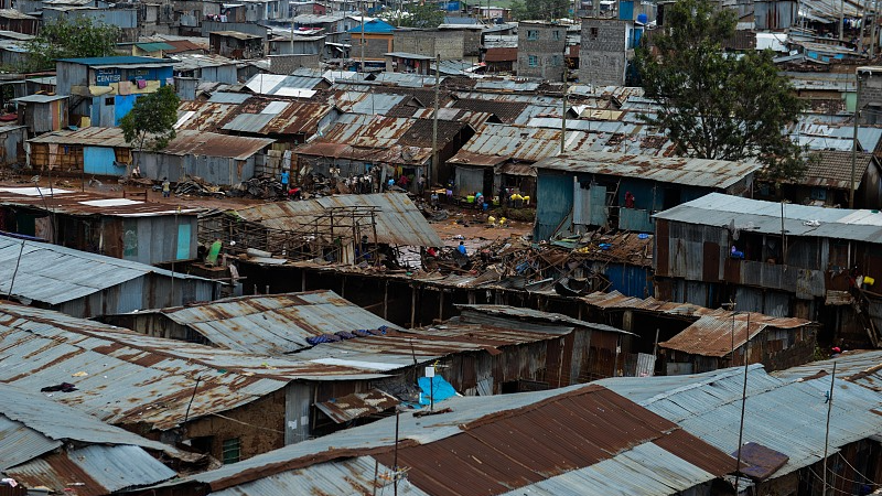 Residents are seen in a flooded street of Mathare neighborhood after heavy rains as they try to evacuate the area with their important belongings in Nairobi, Kenya, April 25, 2024. /CFP