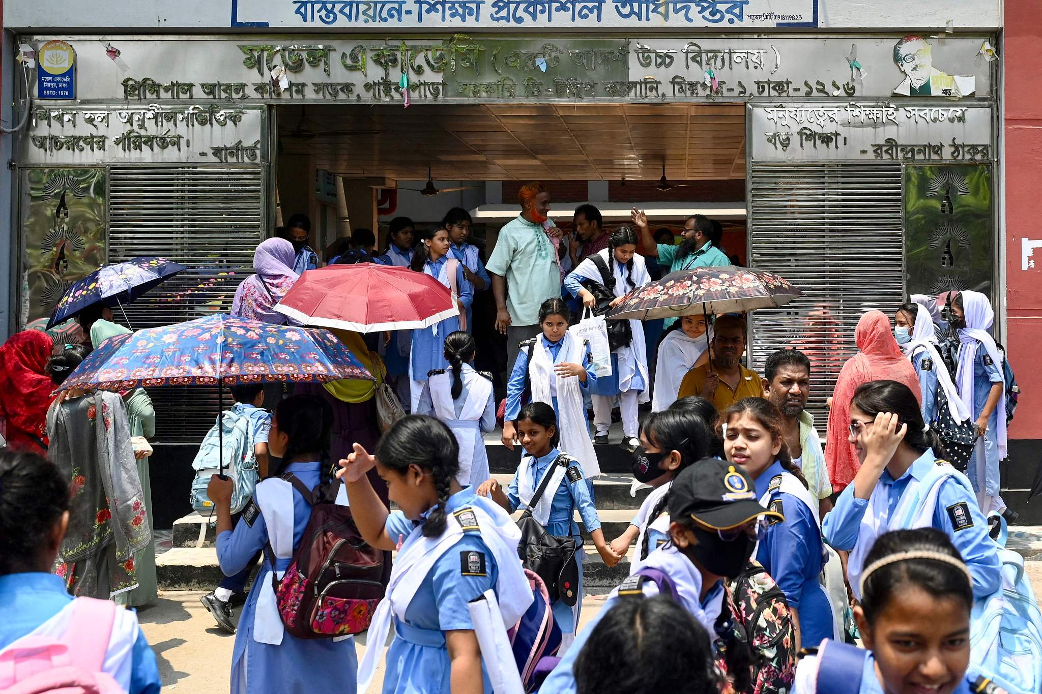 Students leaving their school compound carry umbrellas on a hot summer day in Dhaka, Bangladesh, April 28, 2024. /CFP