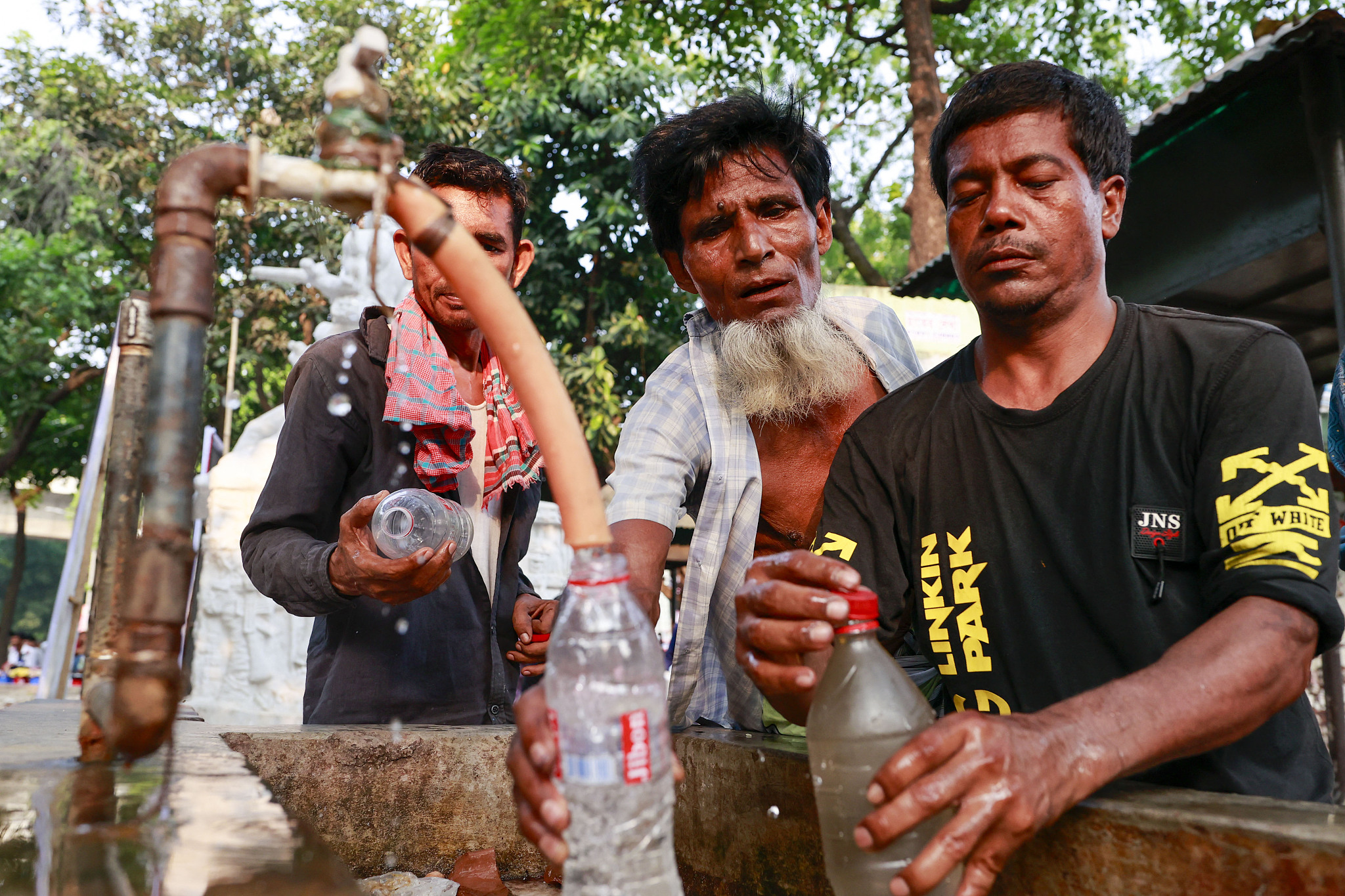 People use roadside tap water to cool down, Dhaka, Bangladesh, April 26, 2024. /CFP
