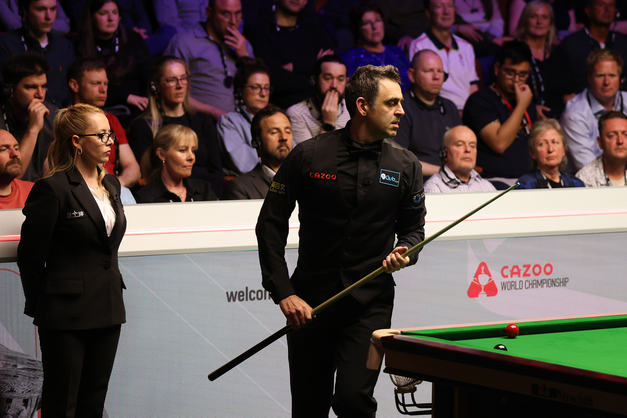 Ronnie O'Sullivan of England prepares to play a shot against Stuart Bingham of England (not pictured) as referee Desislava Bozhilova (L) looks on in the quarterfinal during the Snooker World Championship at the Crucible Theater in Sheffield, England, May 1, 2024. /CFP