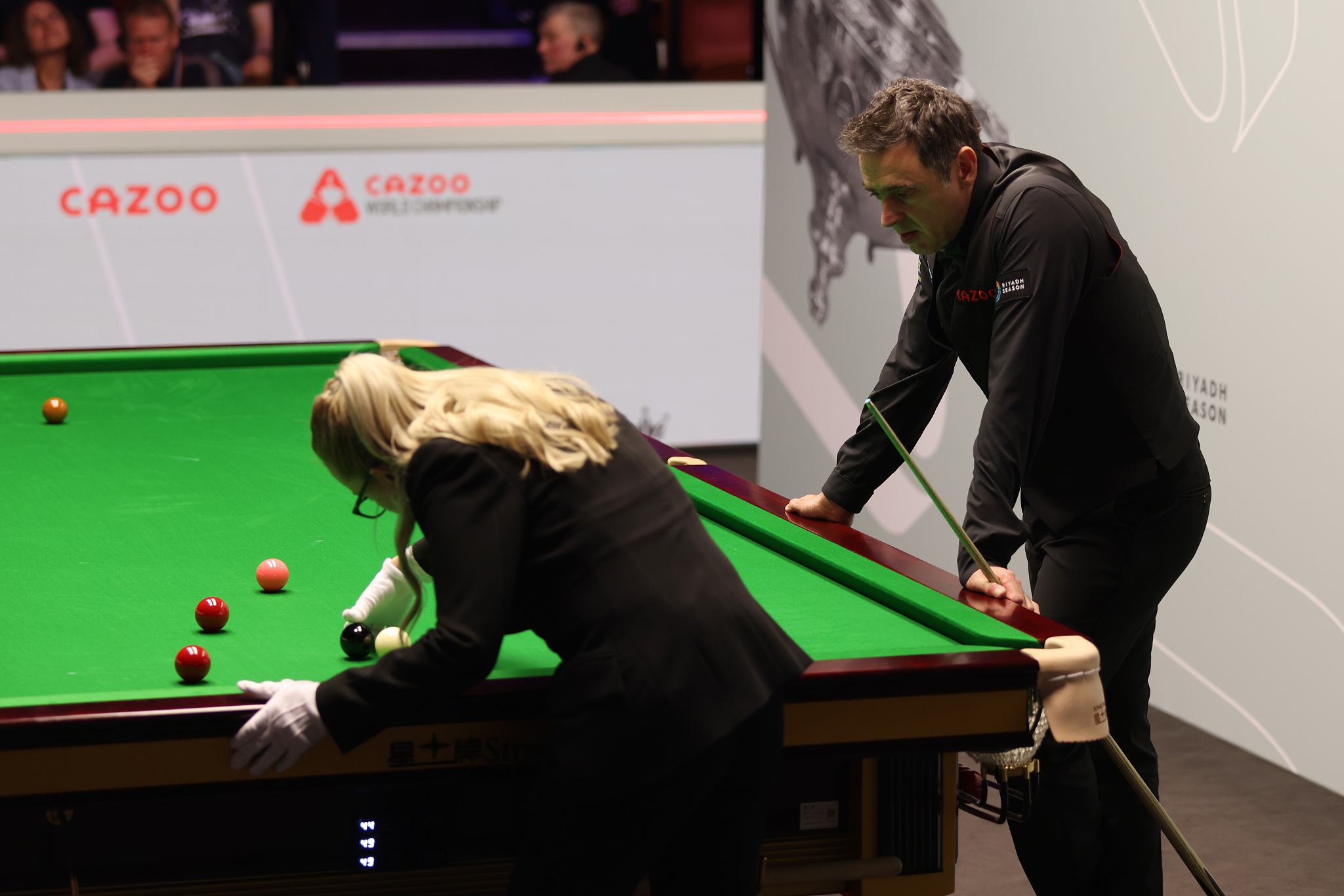 Referee Desislava Bozhilova (L) re-spots the black ball as Ronnie O'Sullivan of England looks on during the Snooker World Championship quarterfinal at the Crucible Theater in Sheffield, England, May 1, 2024. /CFP
