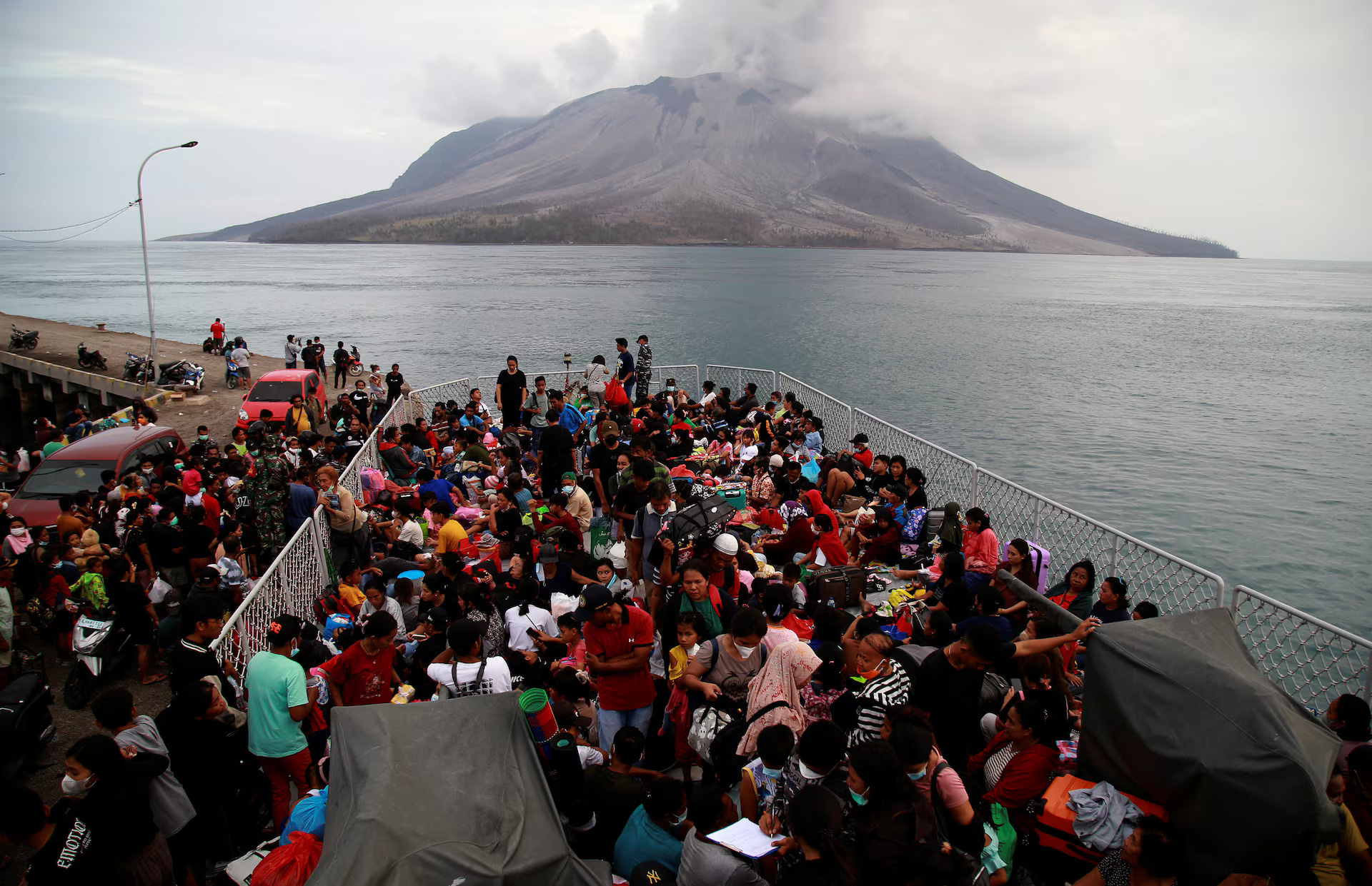 People board the KRI Kakap-881 warship in the port of Tagulandang, to be evacuated to North Minahasa Regency on Sulawesi island, following the eruptions of Mount Ruang volcano in Sitaro, North Sulawesi province, Indonesia, May 1, 2024. /Reuters
