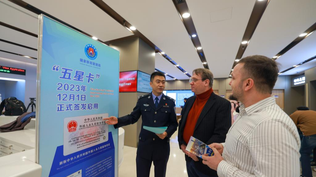 A Chinese police officer explains as guests learn about the new-version of Foreign Permanent Resident ID Card at the department of exit-entry administration of Tianjin Municipal Public Security Bureau in Tianjin, north China, December 1, 2023. China's policies are increasingly geared towards attracting global talent to counteract an aging population and to boost innovation. /Xinhua