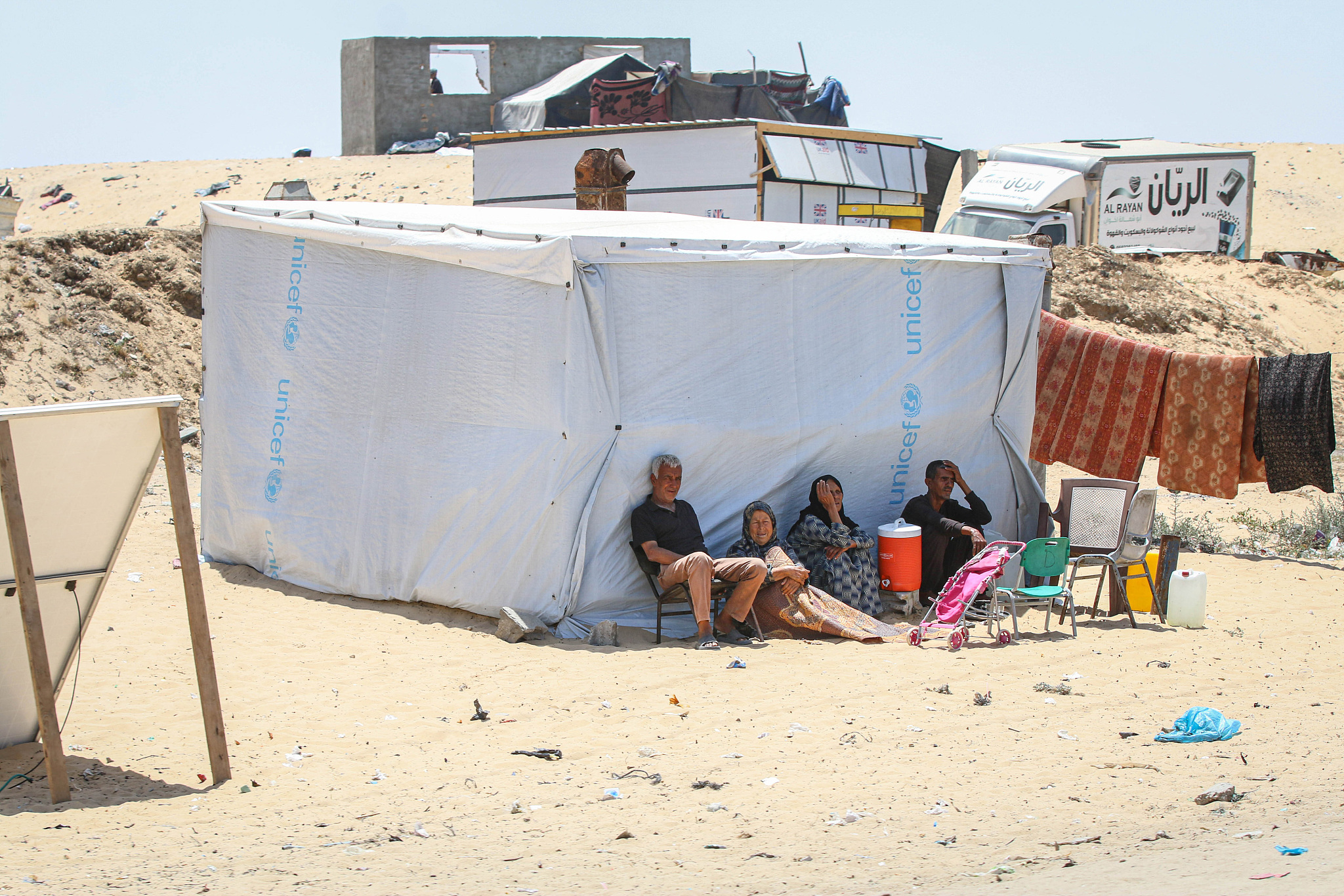 Displaced Palestinians shelter from the sun beside a makeshift tent at a camp in Rafah, southern Gaza, May 3, 2024. /CFP