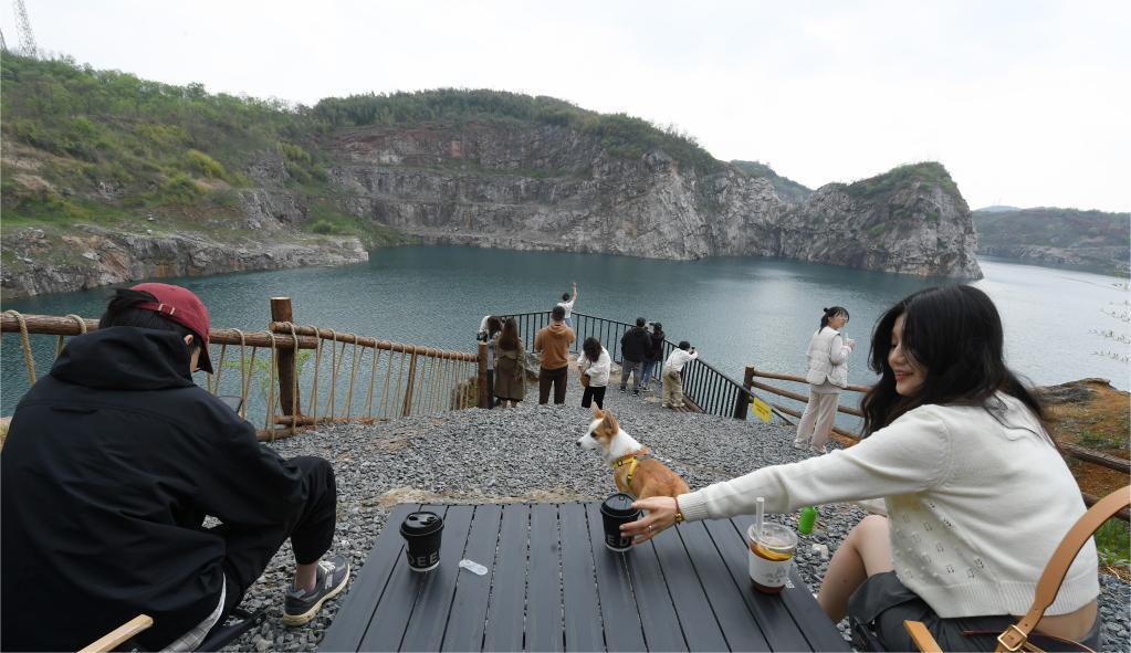 People relax and drink coffee beside a river in Anji County, Huzhou City, east China's Zhejiang Province, April 7, 2023. /Xinhua