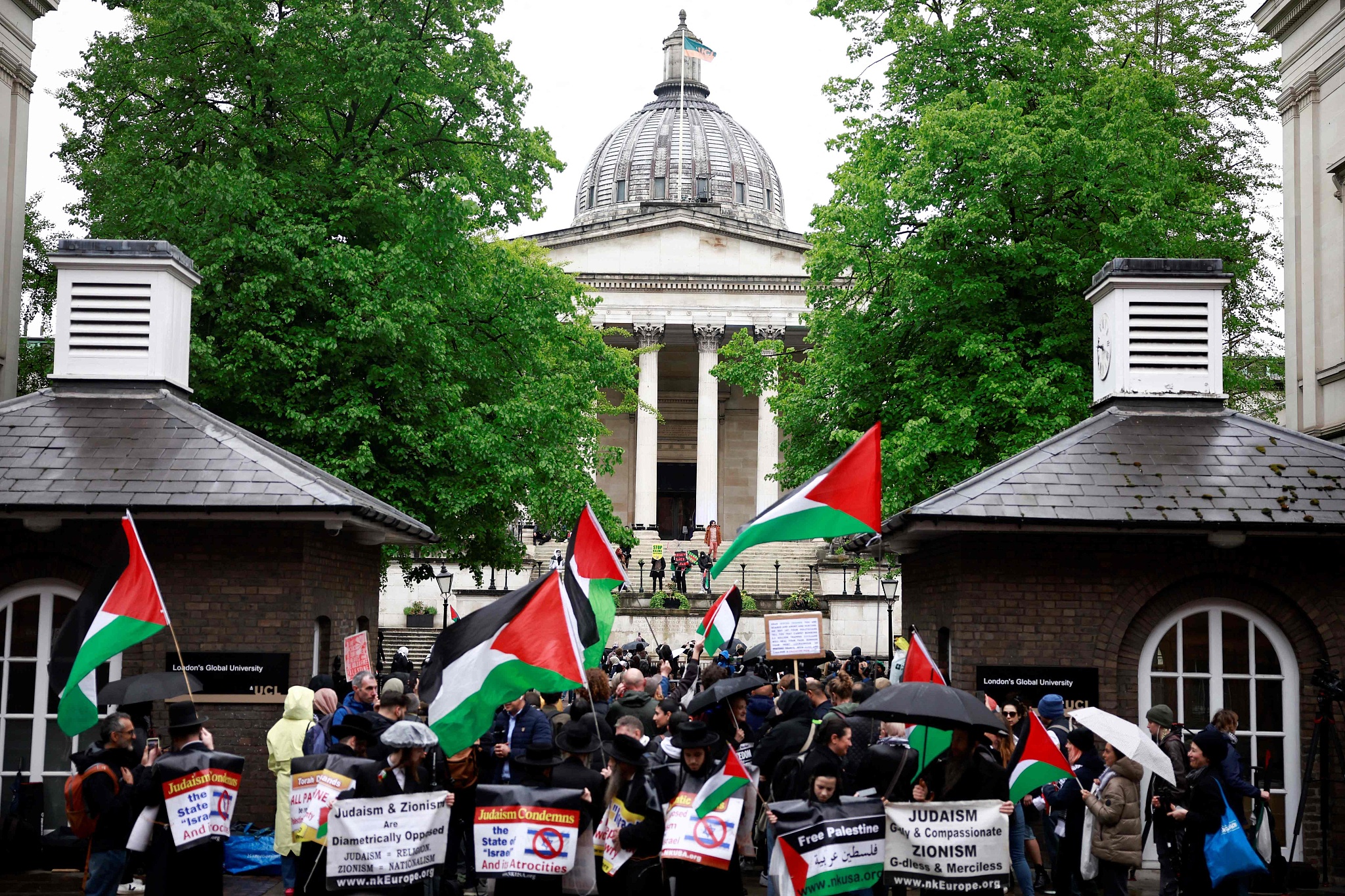 People hold placards and wave Palestinian flags as they take part in demonstration in support to Palestinian people at University College London (UCL) main entrance, London , May 3, 2024. /CFP