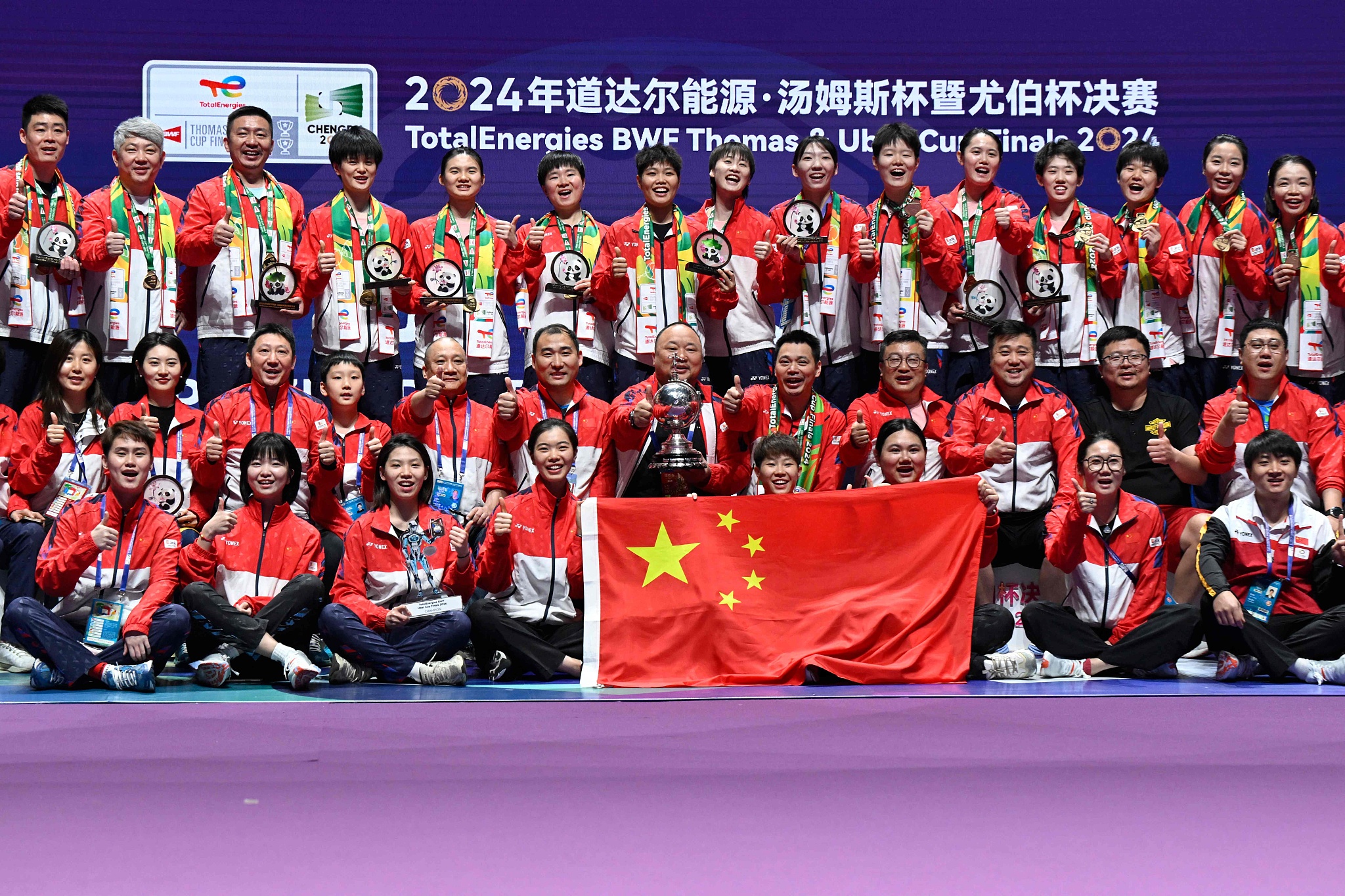 Members of Chinese women's badminton national team celebrate with the national flag and the trophy after winning the Uber Cup title in Chengdu, China, May 5, 2024. /CFP
