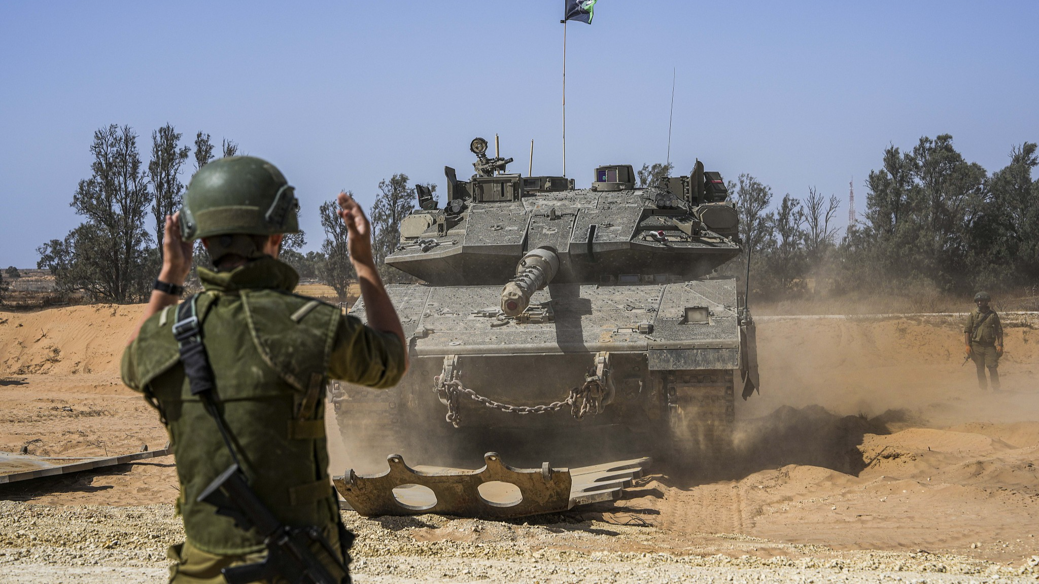 Israeli soldiers direct a tank at a staging ground near the border with the Gaza Strip, in southern Israel, May 5, 2024. /CFP 