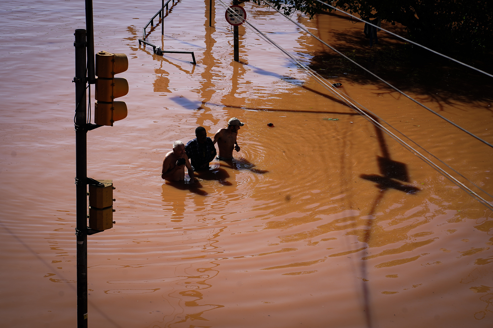 Residents walk through floodwater following heavy rains in Porto Alegre, Rio Grande do Sul state, Brazil, on Monday, May 6, 2024. /CFP