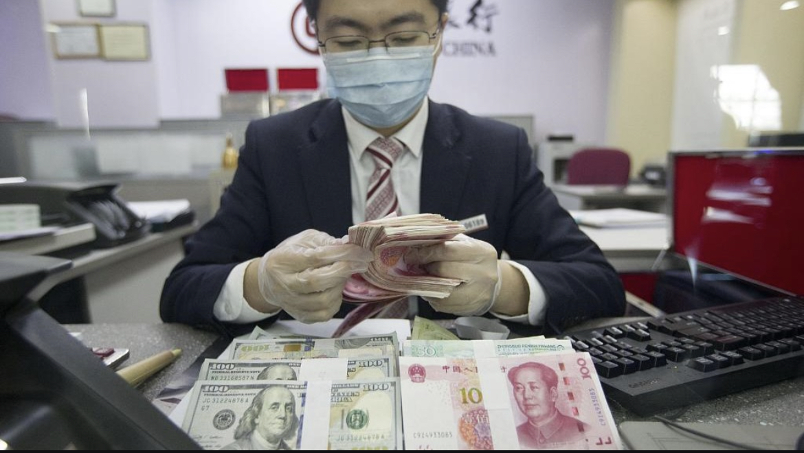 Bank employee counting currency in north China's Shanxi Province, March 13, 2020. /CFP