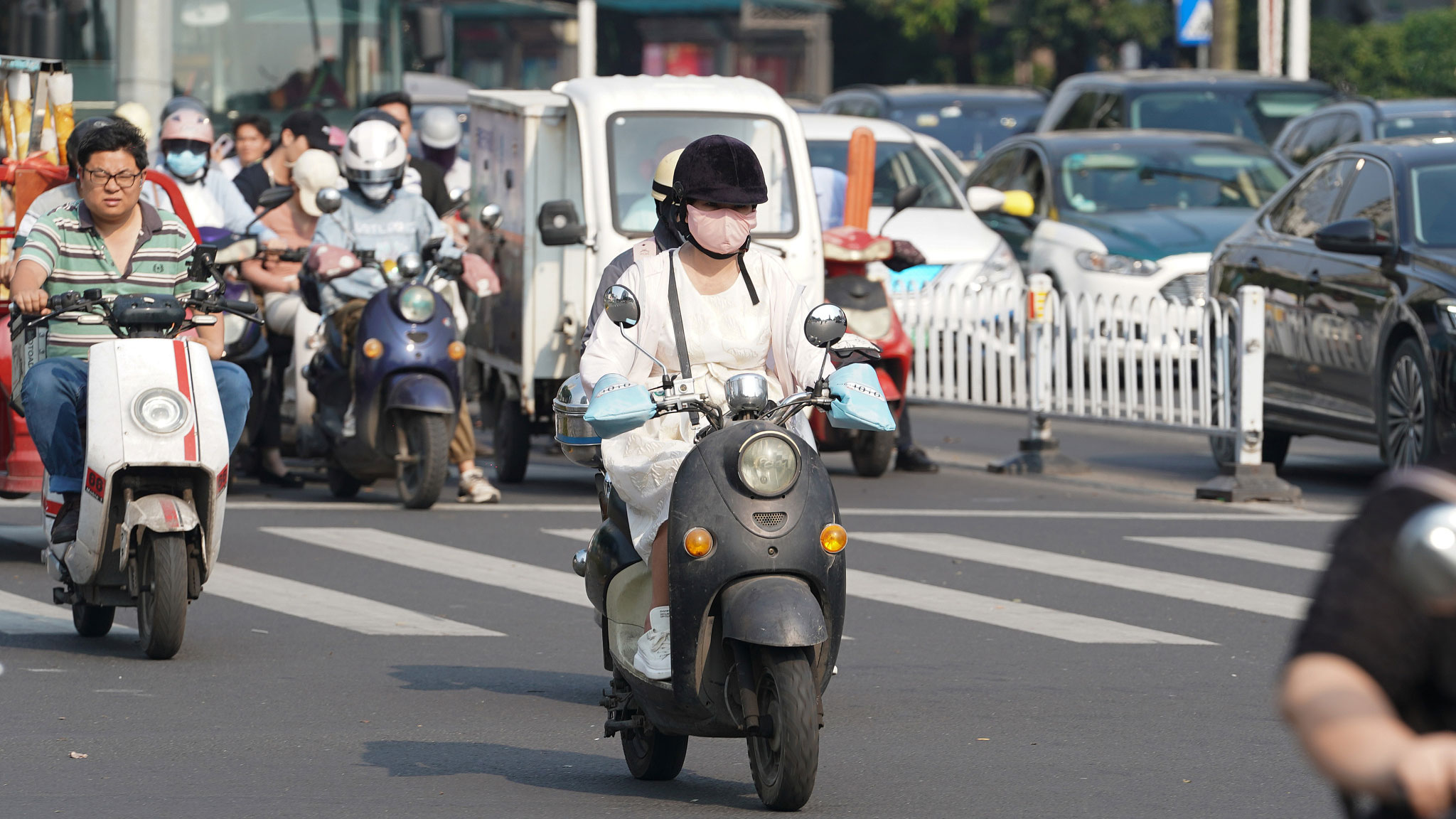 Residents ride e-bikes on the road, Nanning City, southwest China's Guangxi Zhuang Autonomous Region, April 3, 2024. /CFP