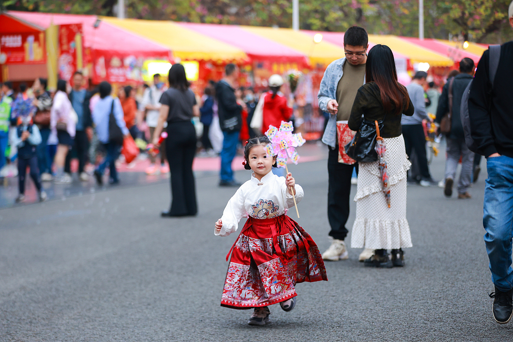 A photo taken on February 4, 2024 shows a girl wearing a mamianqun at a flower market in Guangzhou, Guangdong Province. /CFP