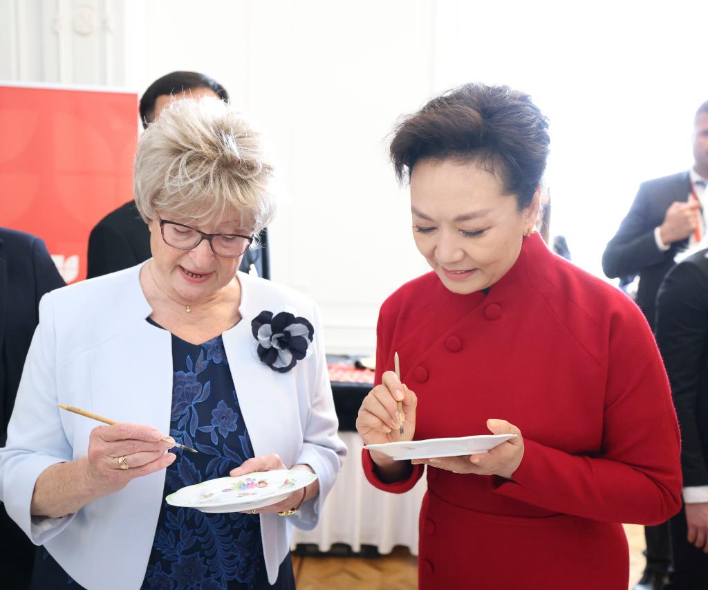 Peng Liyuan, wife of Chinese President Xi Jinping, appreciates the exquisite restoration skills of Hungarian experts with Zsuzsanna Nagy, wife of Hungarian President Tamas Sulyok, in Budapest, Hungary on May 9, 2024. /Xinhua