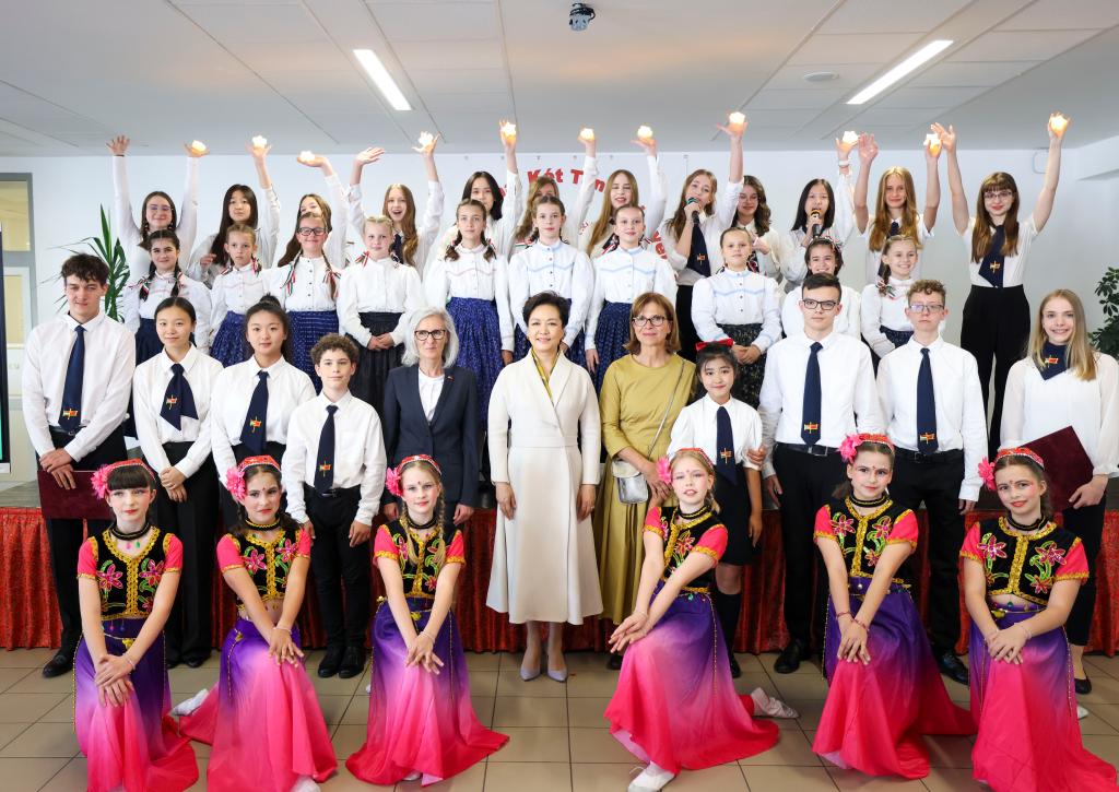 Peng Liyuan, wife of Chinese President Xi Jinping, and Aniko Levai, Hungarian Prime Minister Viktor Orban's wife, pose for photos with students at the Hungarian-Chinese bilingual school in Budapest, Hungary on May 9, 2024. /Xinhua
