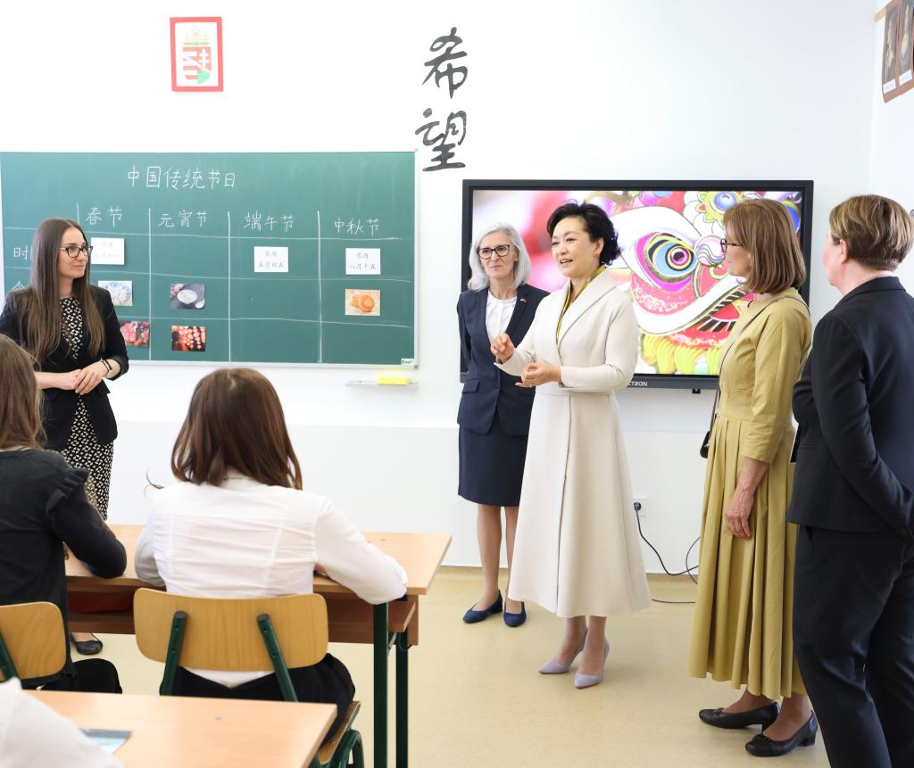 Peng Liyuan, wife of Chinese President Xi Jinping, and Aniko Levai, Hungarian Prime Minister Viktor Orban's wife, have cordial exchanges with students at the Hungarian-Chinese bilingual school in Budapest, Hungary on May 9, 2024. /Xinhua