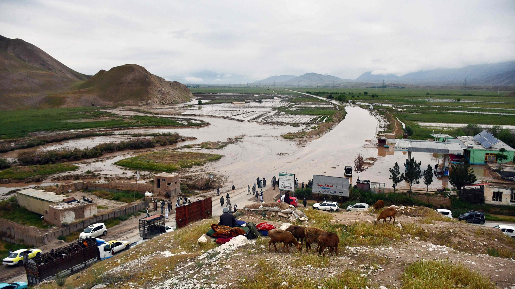 Afgan people gather along a road before a flooded area between Samangan and Mazar-i-Sharif following a flash flood after a heavy rainfall in Feroz Nakhchir district of Samangan Province on May 11, 2024. /CFP