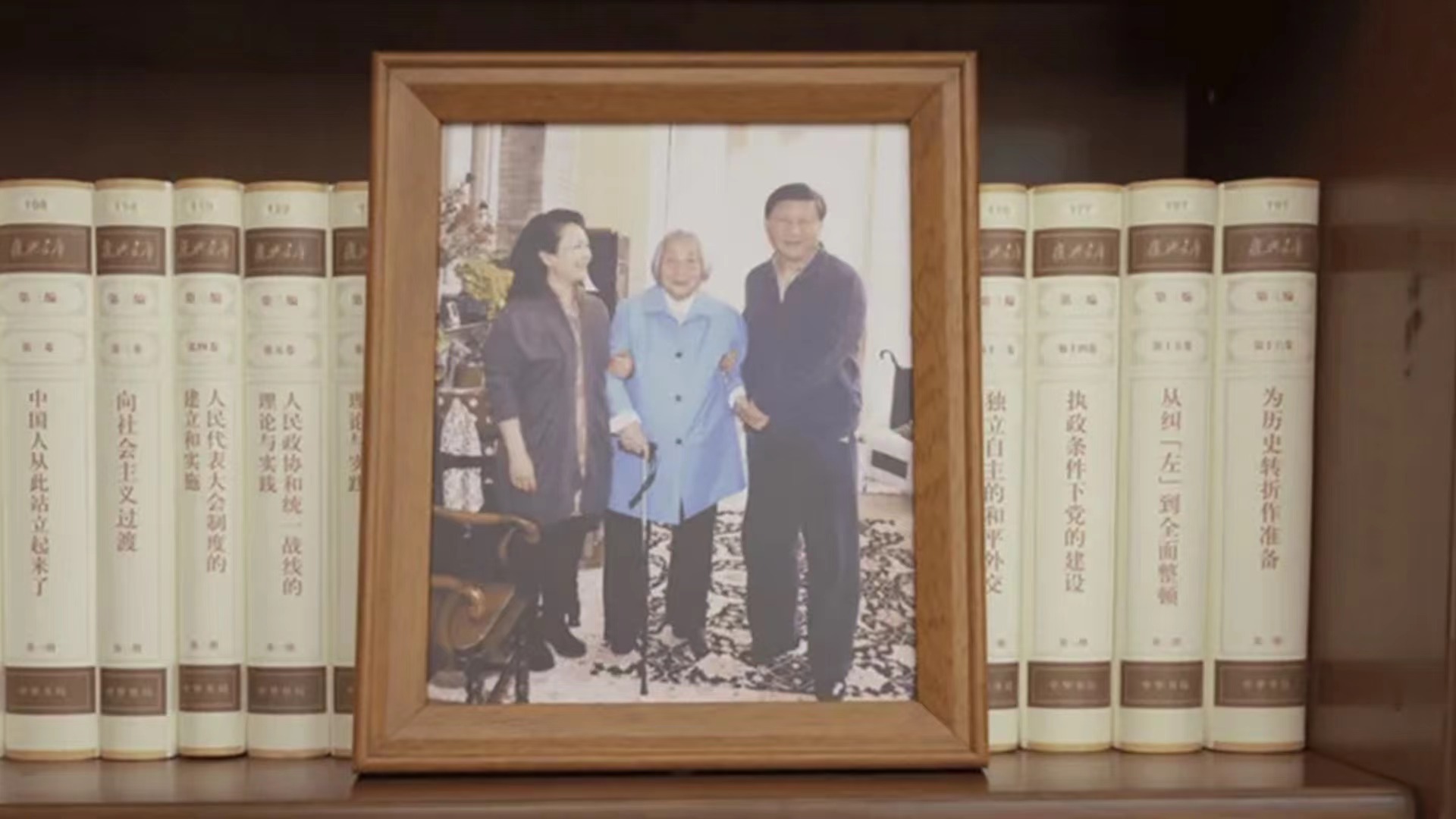 A photo of Chinese President Xi Jinping (R), his wife Peng Liyuan (L), with his mother Qi Xin (C). /CMG