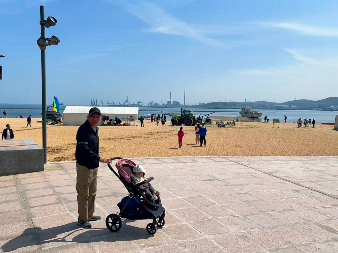 Sun Xue's father-in-law walks his grandson at a seaside park in Weihai City, eastern China's Shandong Province, May 2, 2024. /Provided by Sun Xue