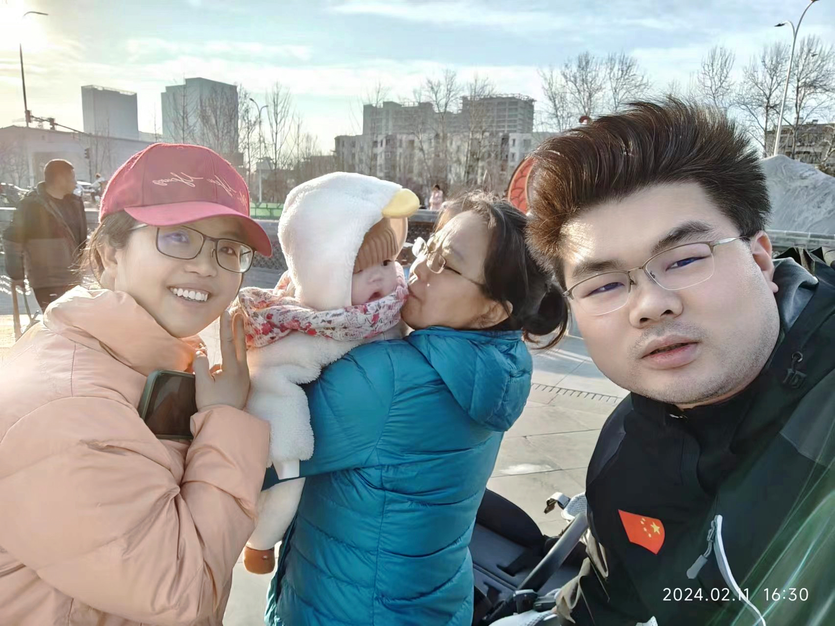Liu Bo (L), her husband (R) and her mother-in-law walk her child at a park, Beijing, capital of China, February 11, 2024. /Provided by Liu Bo