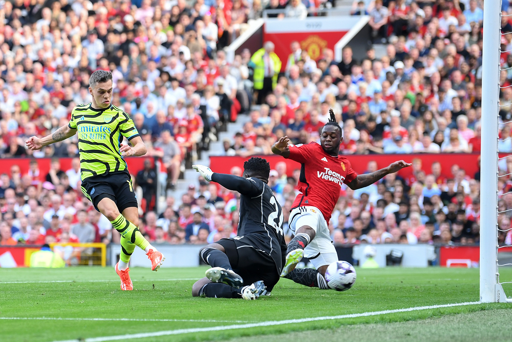 Leandro Trossard (L) of Arsenal scores his team's first goal as goalkeeper Andre Onana (C) and Aaron Wan-Bissaka of Manchester United fail to stop the ball during their clash at Old Trafford in Manchester, England, May 12, 2024. /CFP