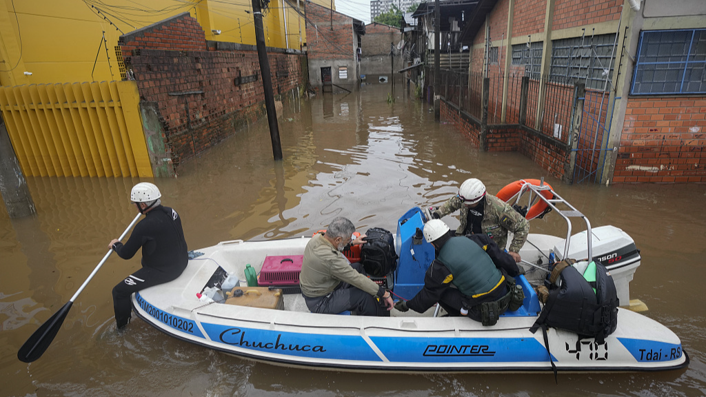 Volunteers evacuate a resident through a street flooded by heavy rain in Porto Alegre, Brazil, Sunday, May 12, 2024. /CFP