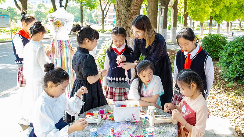 A teacher shows students how to make knot works at a primary school in Huai'an, east China's Jiangsu Province, May 14, 2024. /CFP
